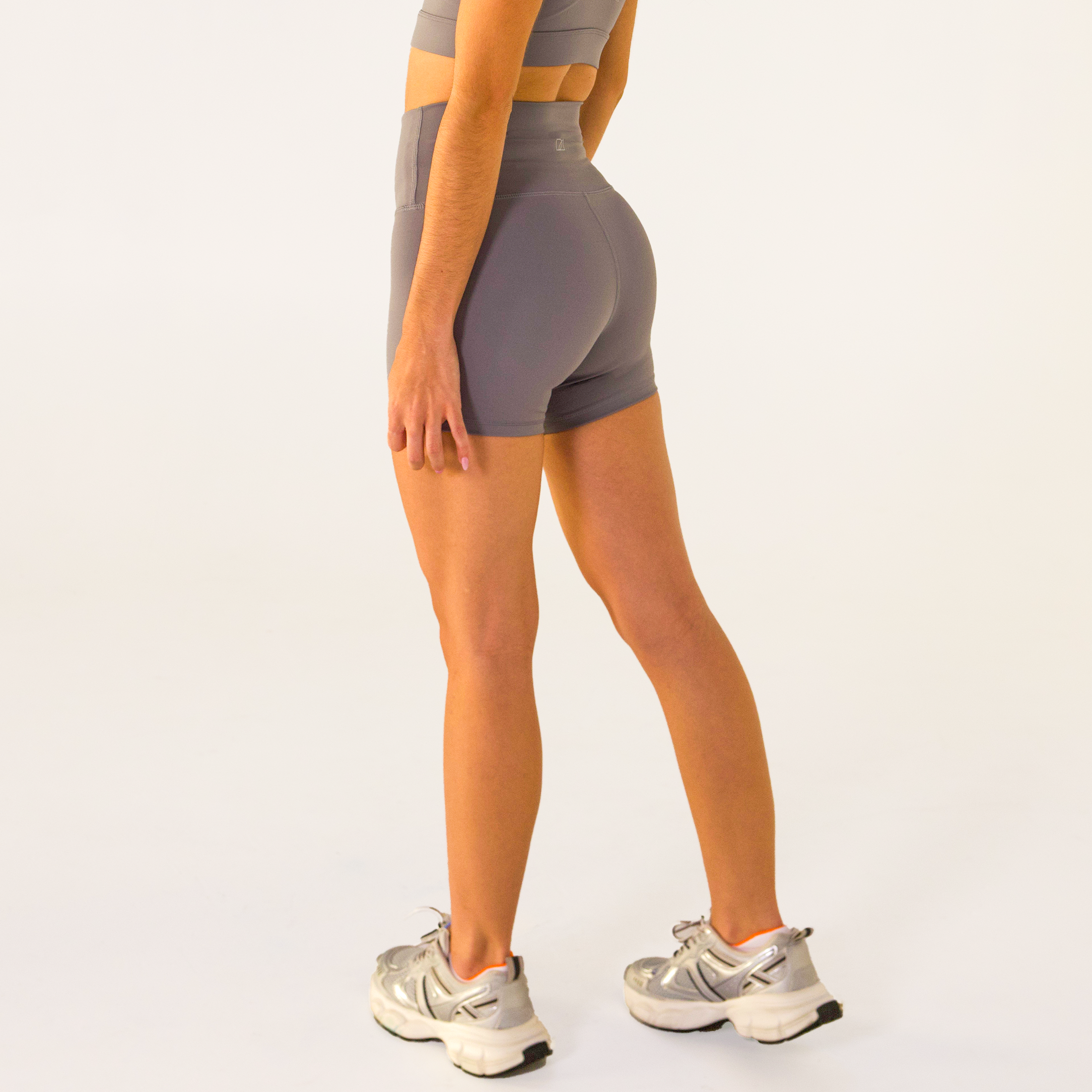 Woman wearing abalone shell Trimline 5" Shorts by Definite Articles. Side profile.