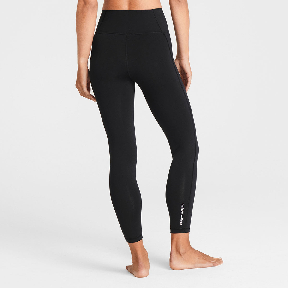Woman wearing black Trimline Natural-Waist 7/8 Leggings by Definite Articles, viewed from behind.
