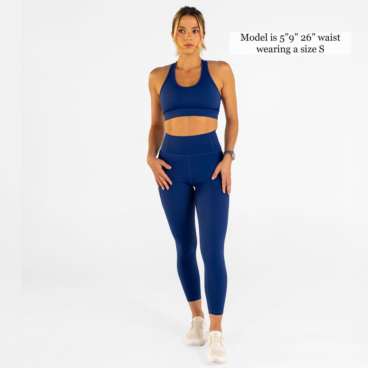 Woman wearing estate blue Trimline Natural-Waist 7/8 Leggings by Definite Articles. Model is 5'9 + 26" waist wearing size S.
