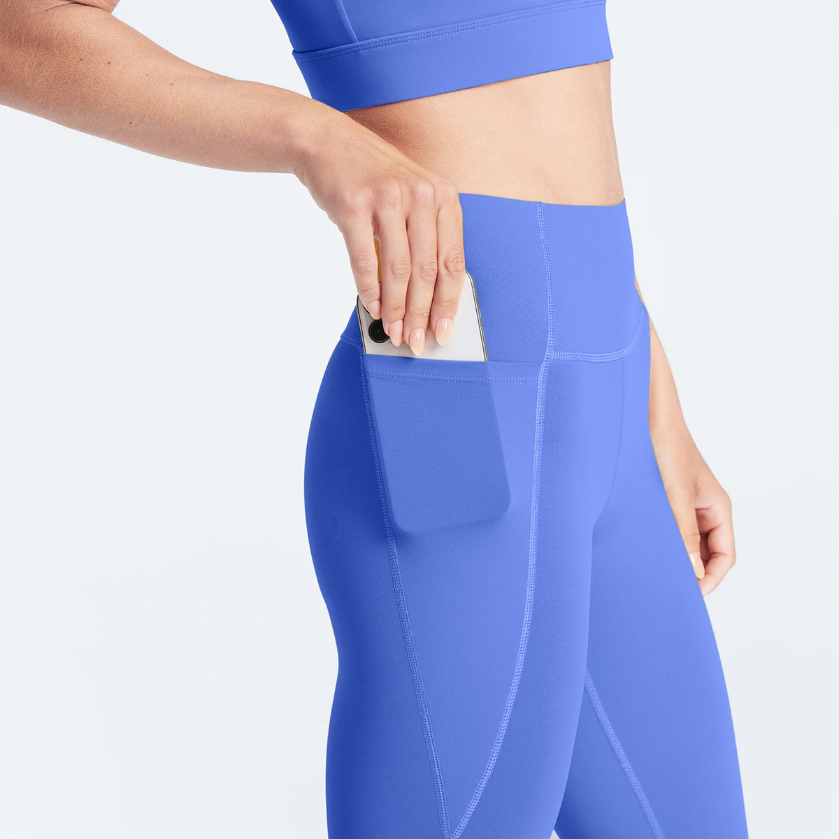 Woman wearing persian jewel Trimline Natural-Waist 7/8 Leggings by Definite Articles. Closeup on pocket.