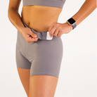 Woman wearing abalone shell Trimline 5" Shorts by Definite Articles. Closeup on pockets.