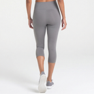 Woman wearing abalone shell Trimline Capri Leggings by Definite Articles. White background.