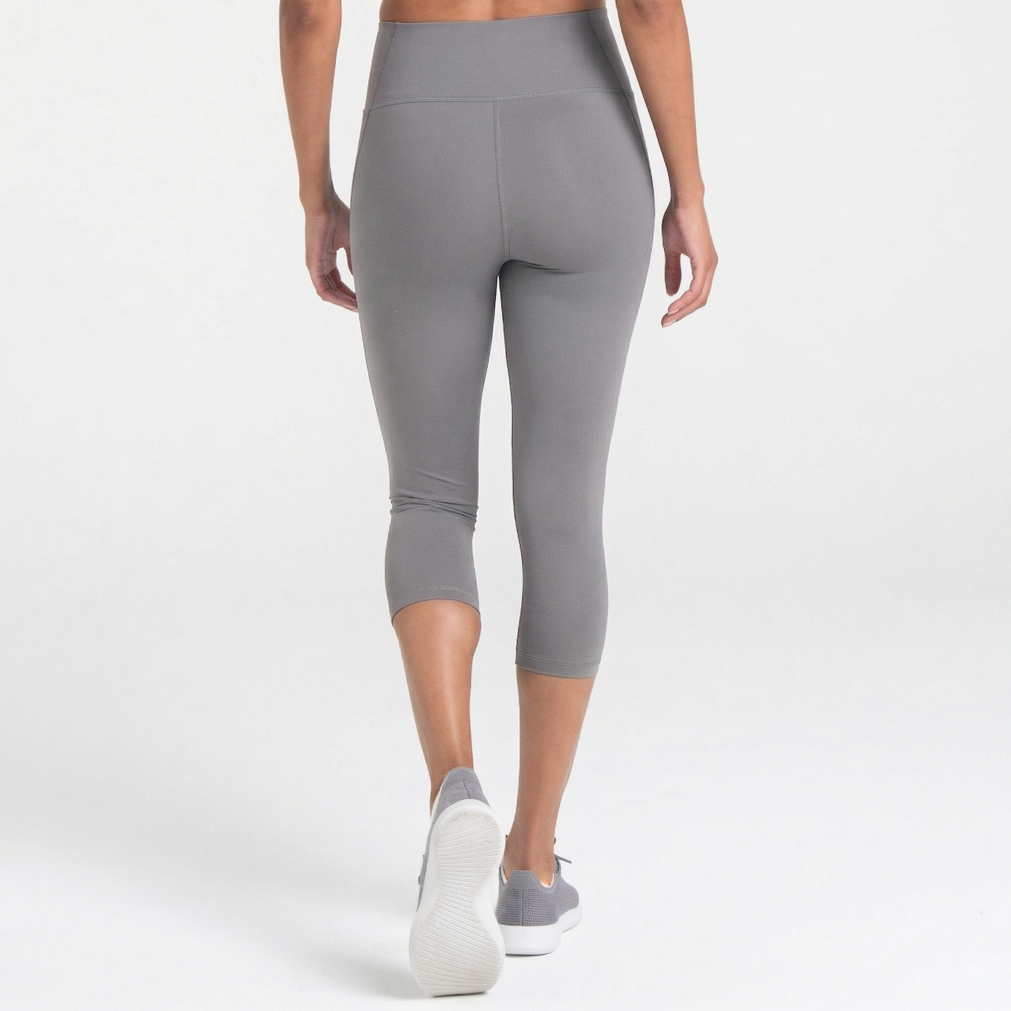 Woman wearing abalone shell Trimline Capri Leggings by Definite Articles. White background.
