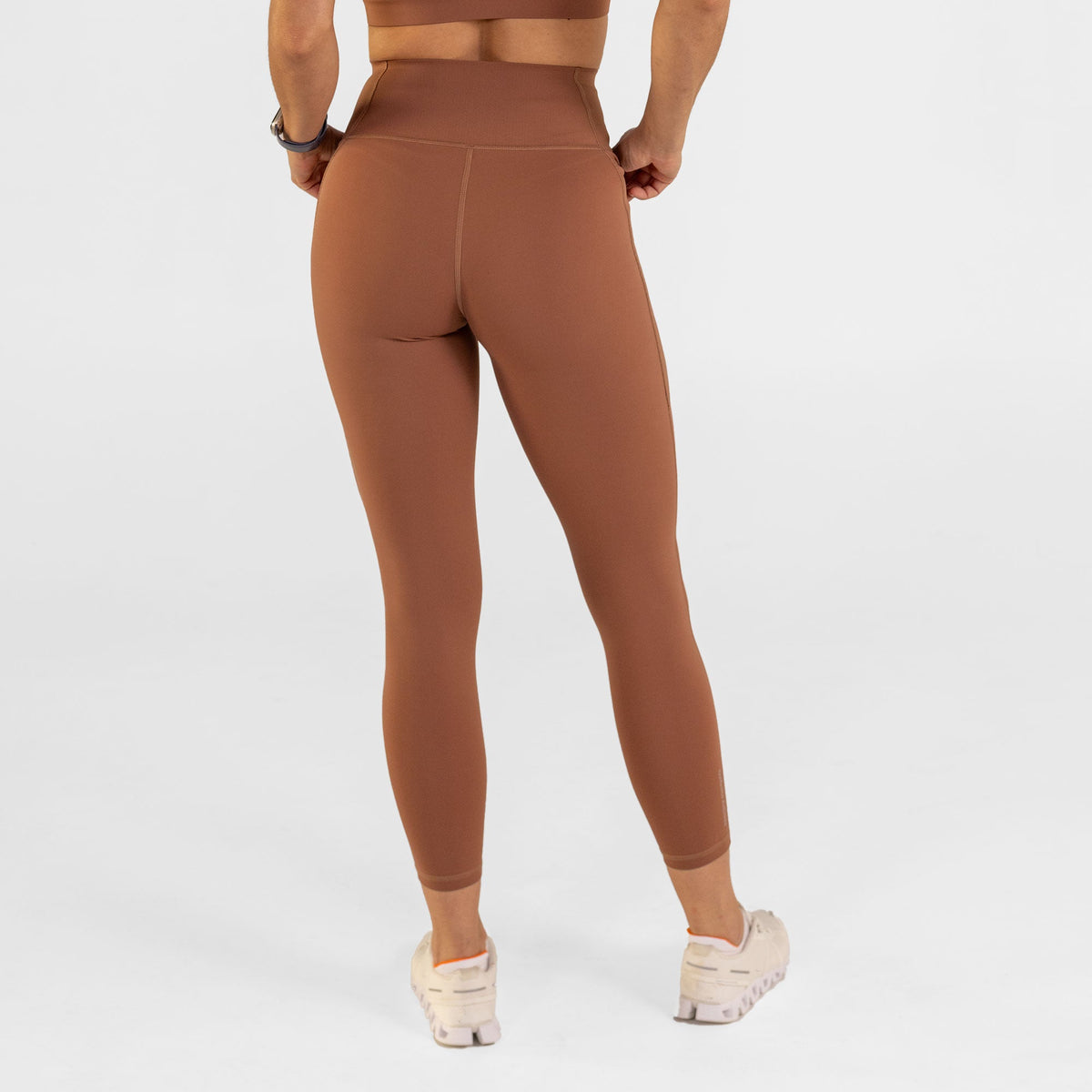 Woman wearing carob brown Trimline Natural-Waist 7/8 Leggings by Definite Articles, as viewed from behind.