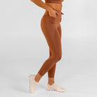 Woman wearing carob brown Trimline 7/8 Leggings by Definite Articles. White background.
