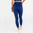 Woman wearing estate blue Trimline Natural-Waist 7/8 Leggings by Definite Articles, seen from behind.