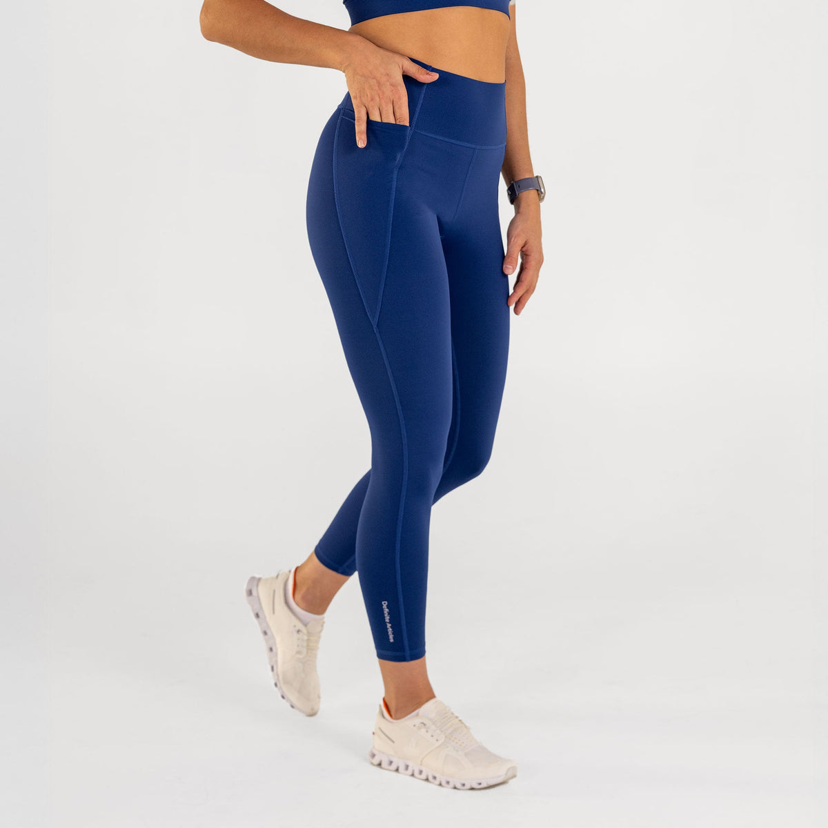Woman wearing estate blue Trimline Natural-Waist 7/8 Leggings by Definite Articles, front pocket.