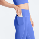 Woman wearing persian jewel Trimline Natural-Waist 7/8 Leggings by Definite Articles. Closeup on pocket.